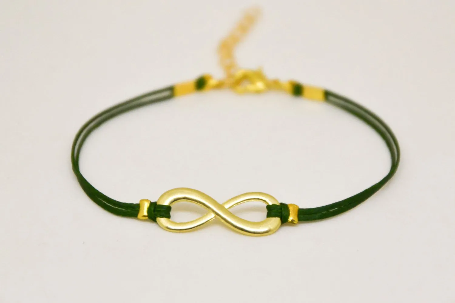 Gold infinity bracelet for women, green cord, yoga jewelry